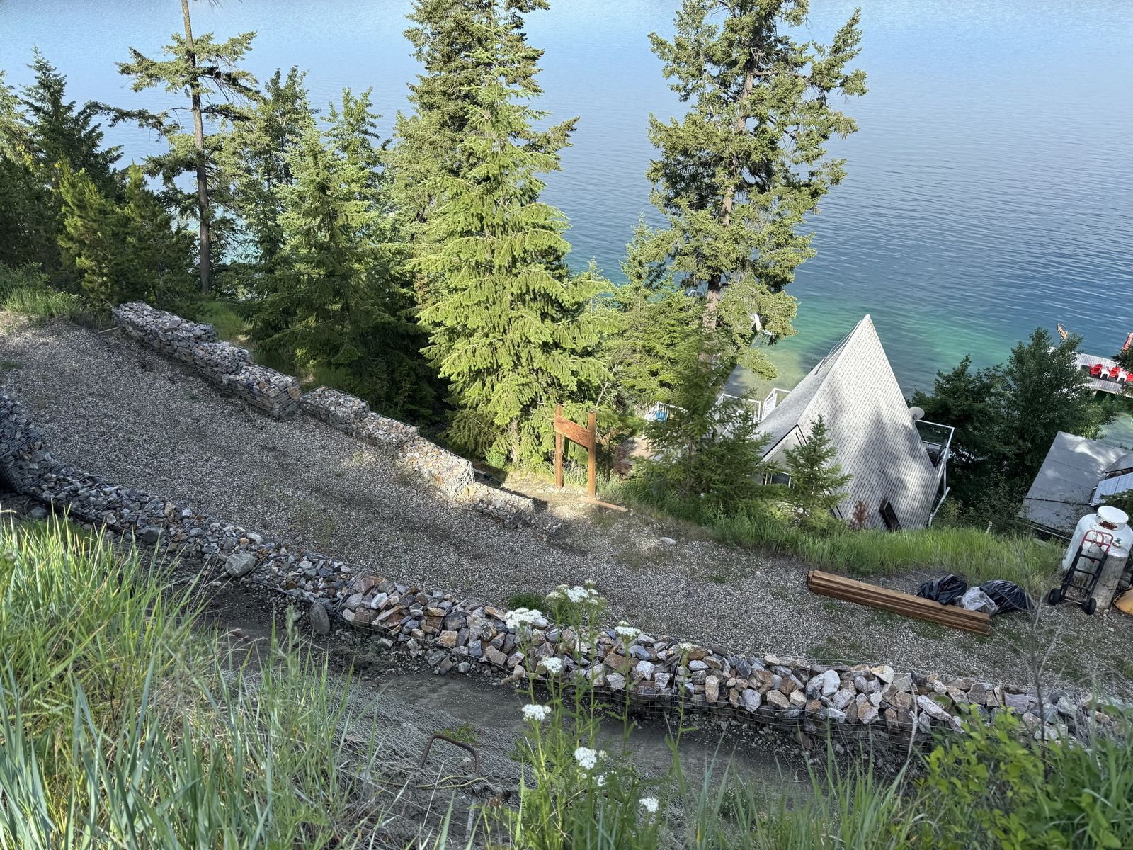 Gabion basket wall and gravel bench on a hillside lot