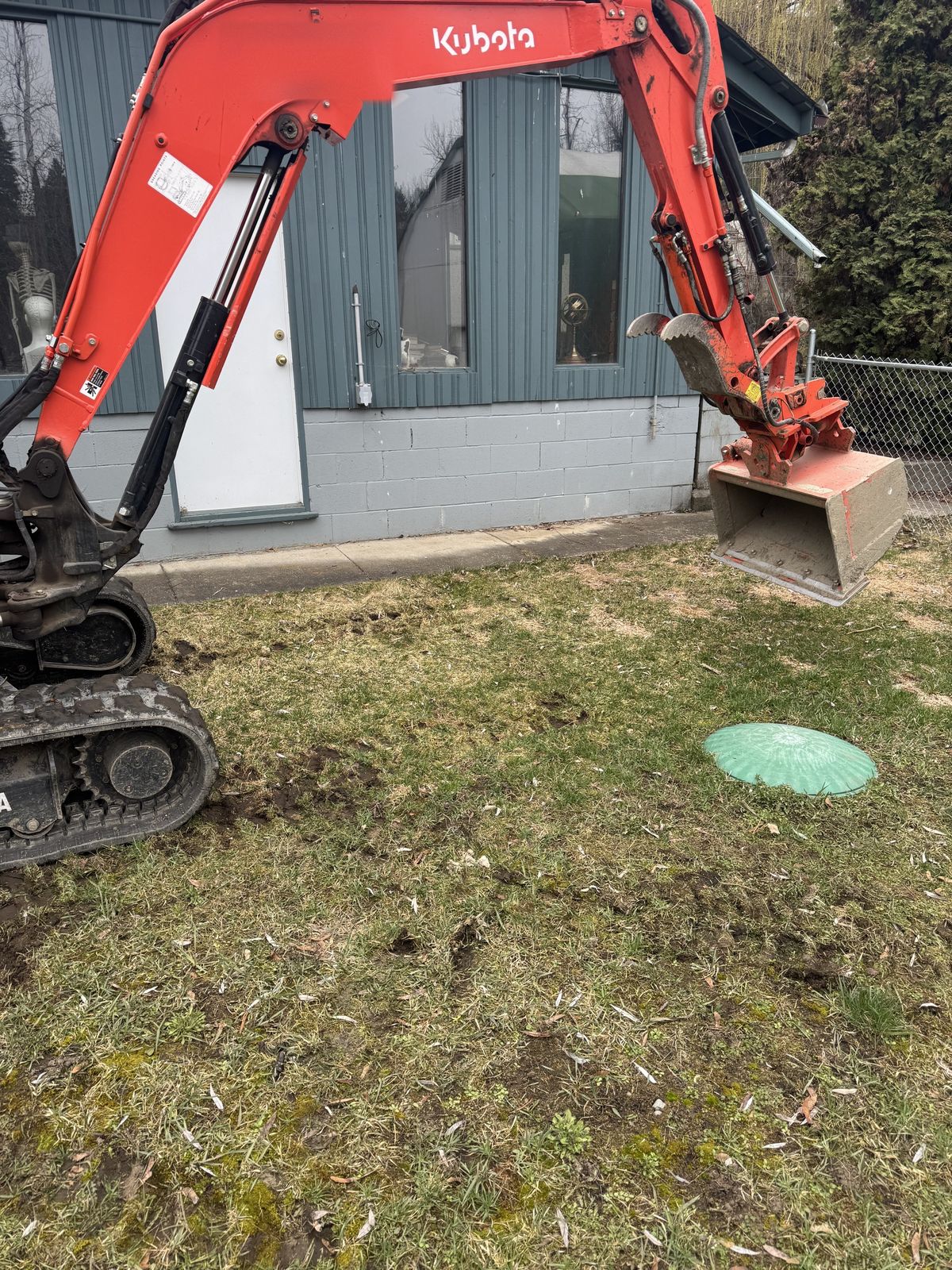 Compact excavator at work on a yard drainage job